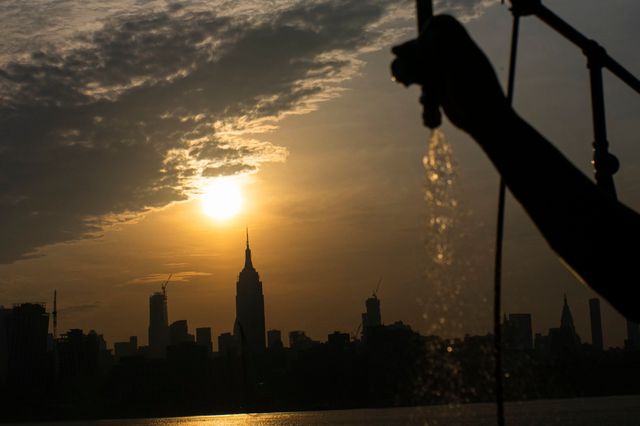 The sun rises over New York City and the Empire State Building.